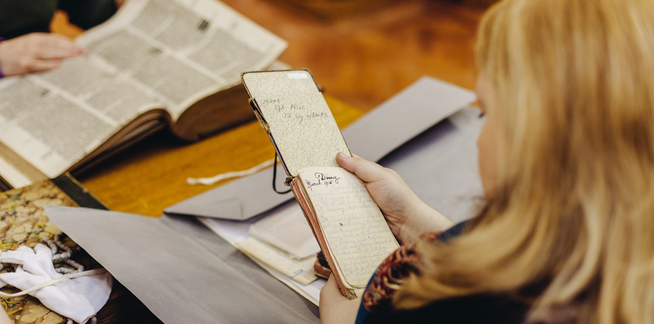 Image of a student in Special Collections, looking at archival material
