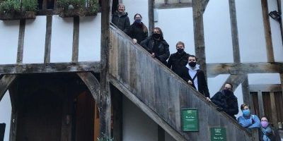 A group of Leeds Medieval Society members stood on the wooden steps of an old building