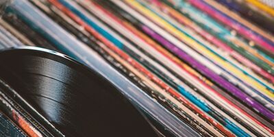 A pile of record sleeves. A vinyl record is pulled out of one.