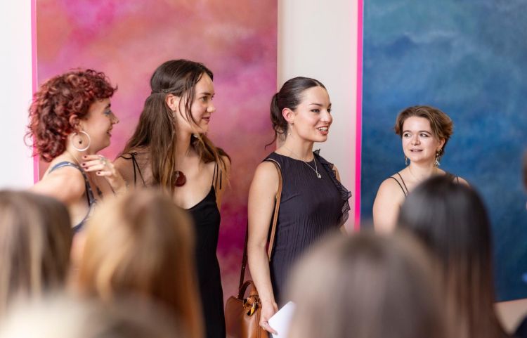 Four members of the curatorial team for make no bones fine art degree show standing in front of a series of paintings