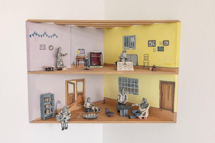 Sculpture of a house by Esme McLean installed in a corner of a gallery