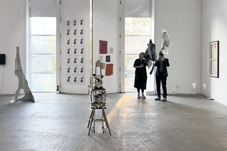 Visitors explore an exhibition in a gallery space.