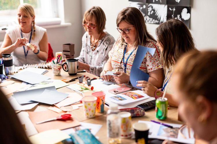 Group of people seated at a table taking part in creative activities