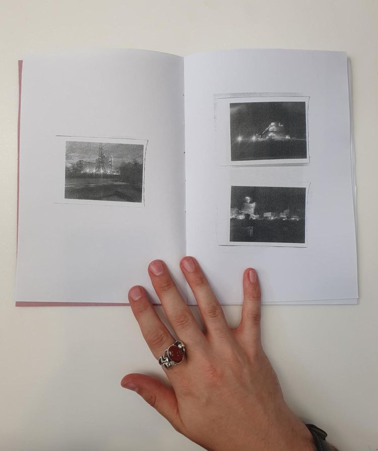 Hand holding open a zine with photos on each page