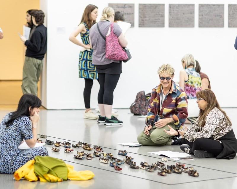 Art teachers sitting down in a gallery space to discuss an artwork