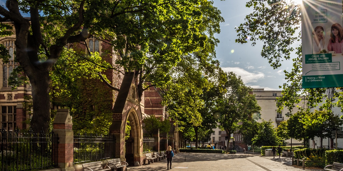 Distance figure walks towards Sadler and Baines on a sunny day