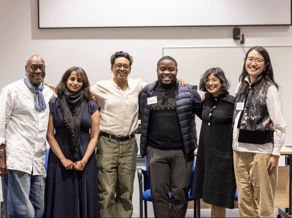 A group of people stand together and smile for a photograph