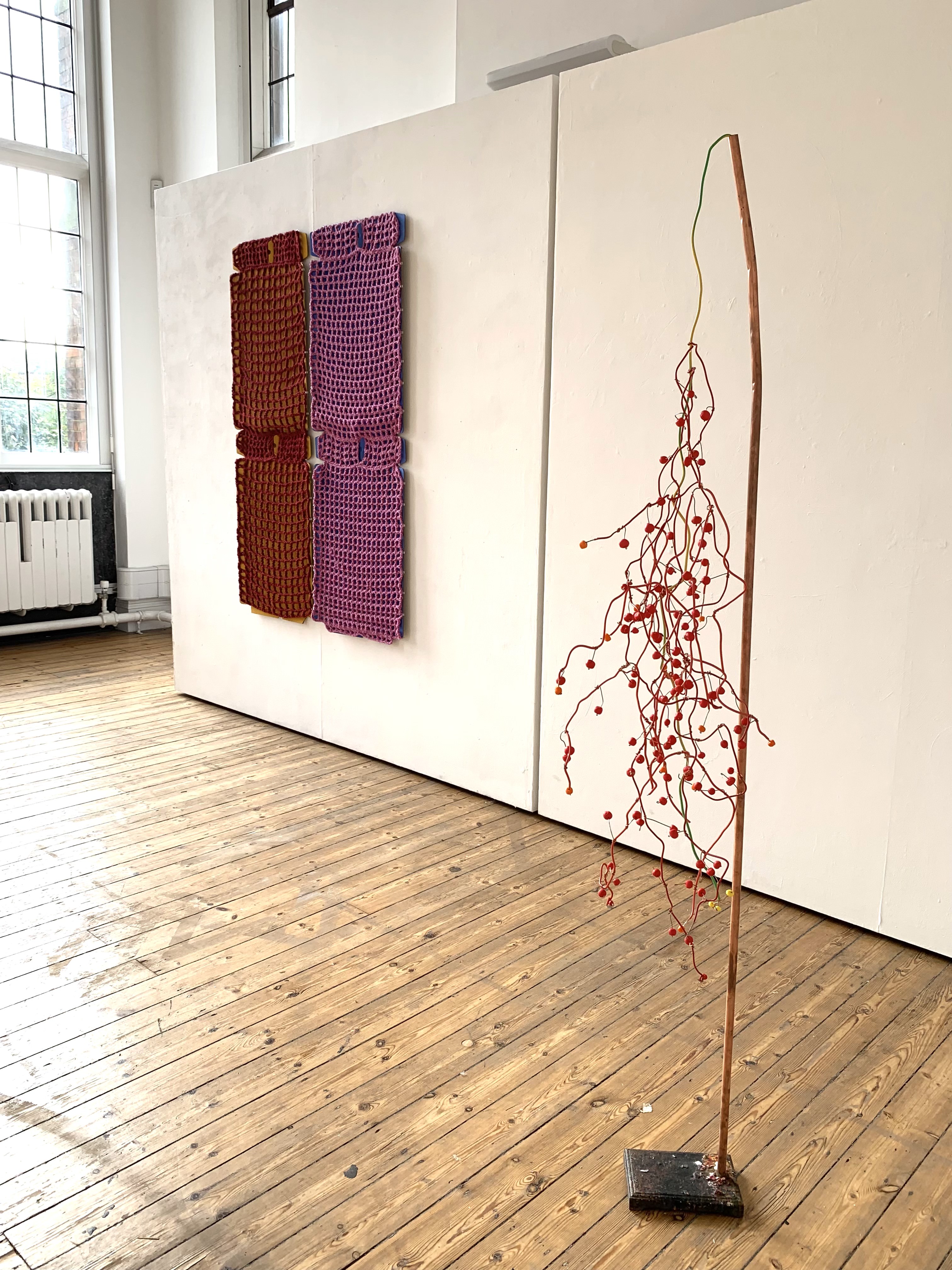 image1 (in betweens E Boukla and D. Gardner i)i.  left Eirini Boukla, title Catch 10, 2023. Materials: Found cardboard box, gouache, wool yarn.
right, Deborah Gardner, title Conduction, 2023.  Materials: repurposed copper pipe and wire, electrical waste cable and clay beads