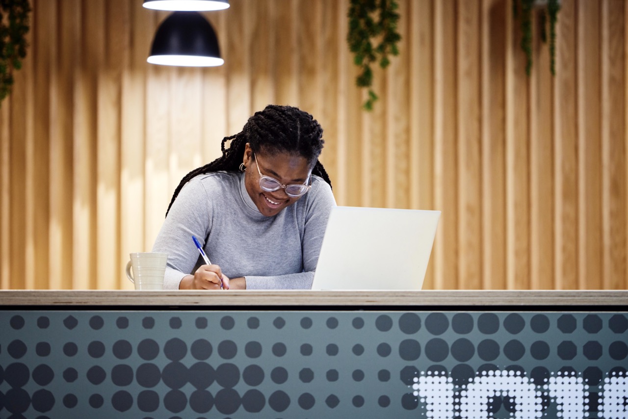 A female student working at a laptop in one of the campus cafes