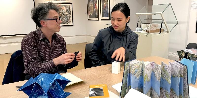 Photo of Chris Taylor and Sufea Mohamad Noor, with artists books in the foreground
