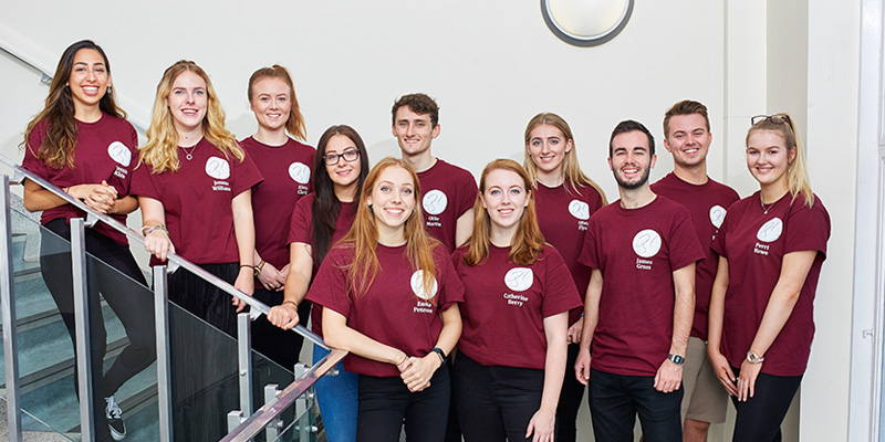 A group of students from the history society wearing matching society t-shirts.
