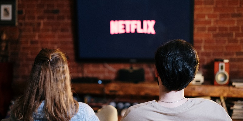 Back of two people&#039;s heads  watching Netflix on TV