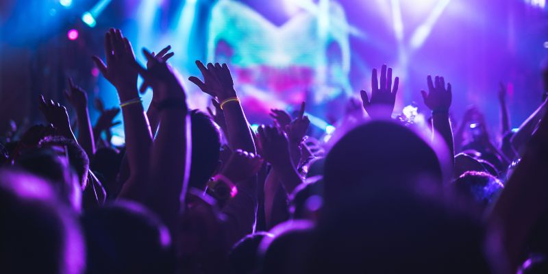 Close up of lots of raised hands in the air applauding at a concert