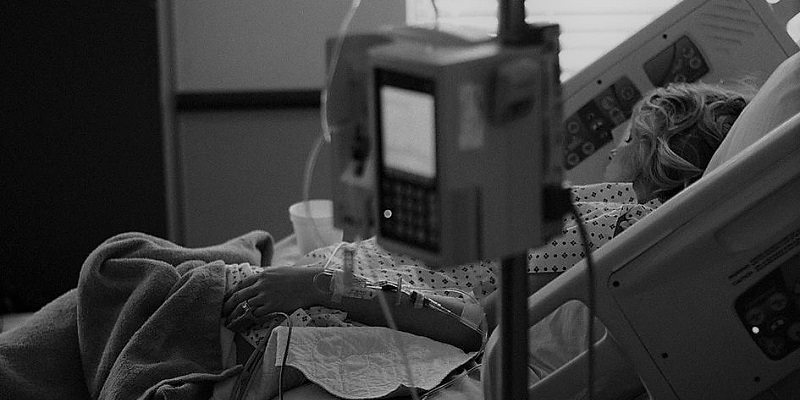 Black and white image of woman in hospital bed