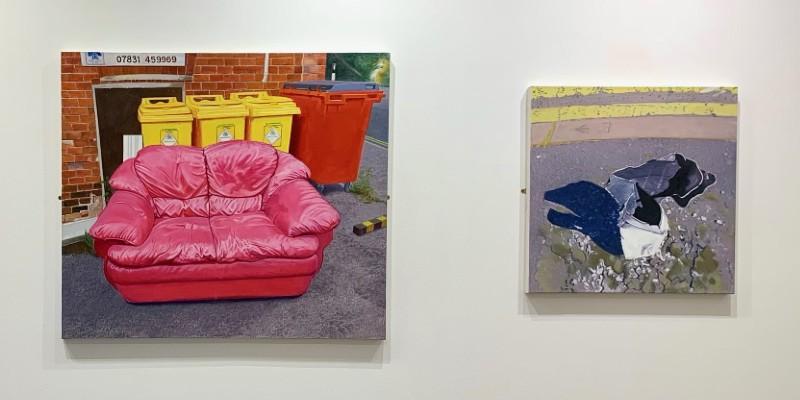 Paintings by Howard Eaglestone on a gallery wall, one of a pink sofa and wheelie bins on a pavement, one of a pavement and double yellow lines