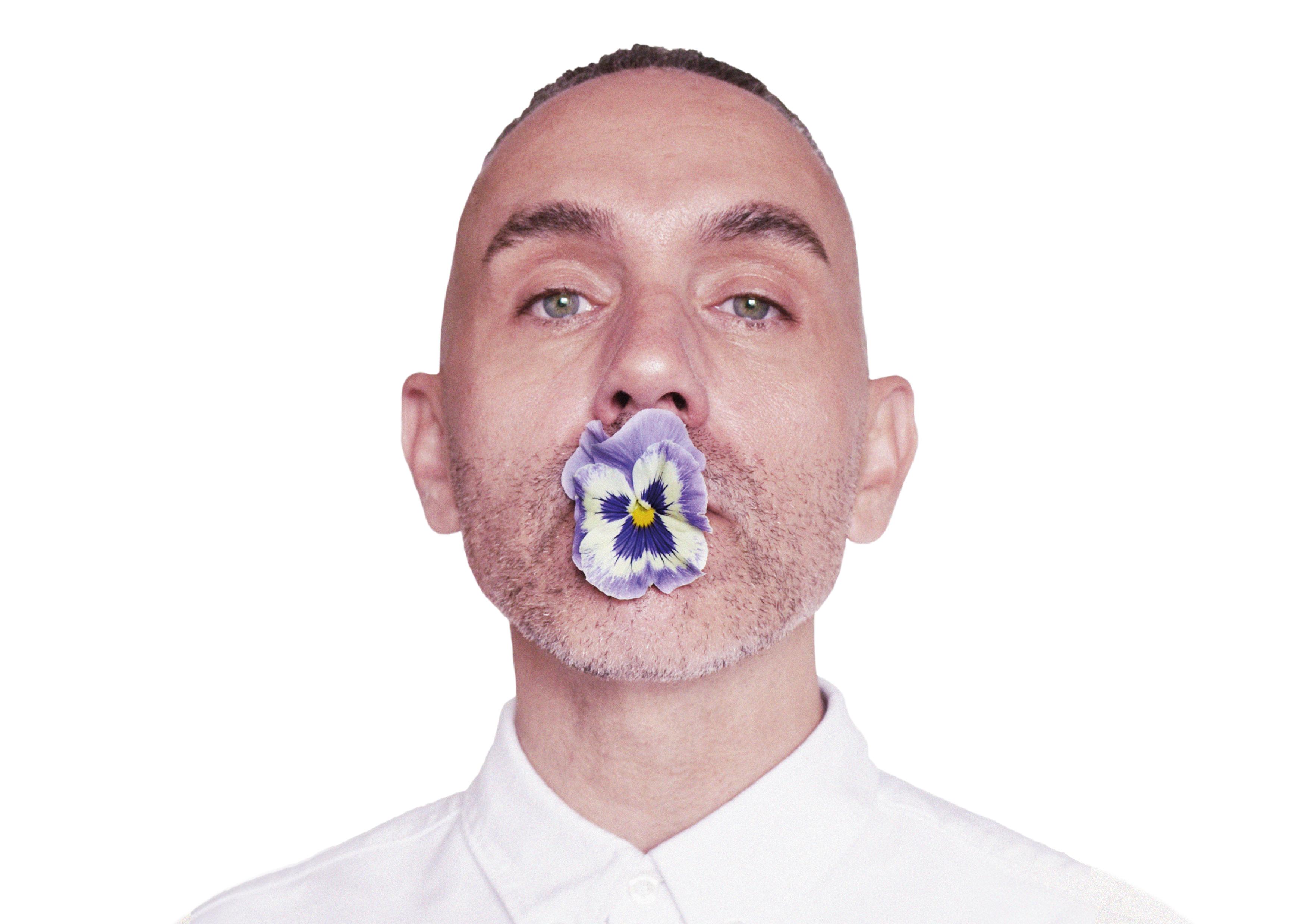 Artist Paul Harfleet with a pansy in his mouth