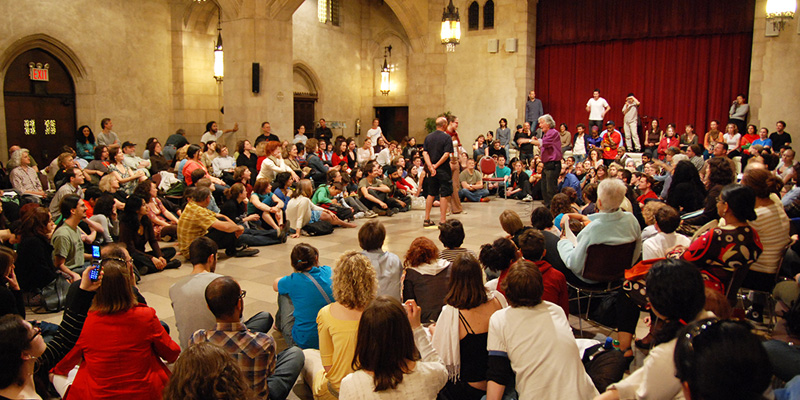 Crowd watching a performance in a large hall.