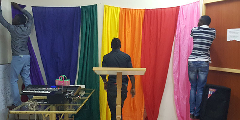 Kenyan's decorating a room with a rainbow flag