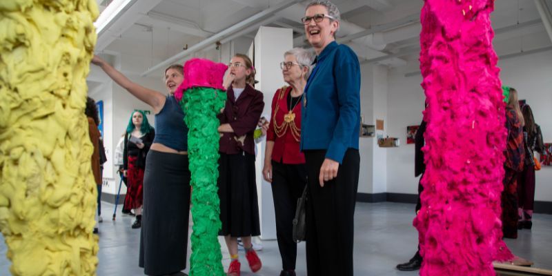 The art show, including installations of tall, brightly coloured columns of fabric.