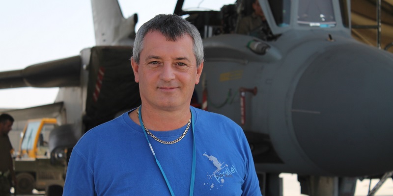 Freelance journalist Mark Nichollsstanding next to a jet
