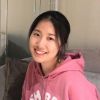 Image for Amber Zhang's student profile. Amber is smiling in front of a neutral coloured background and wears a pink hoodie with white text on the front, on which you can only see the top of the letters.