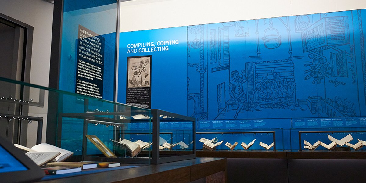 Interior of a museum displaying old manuscripts and books in glass cases