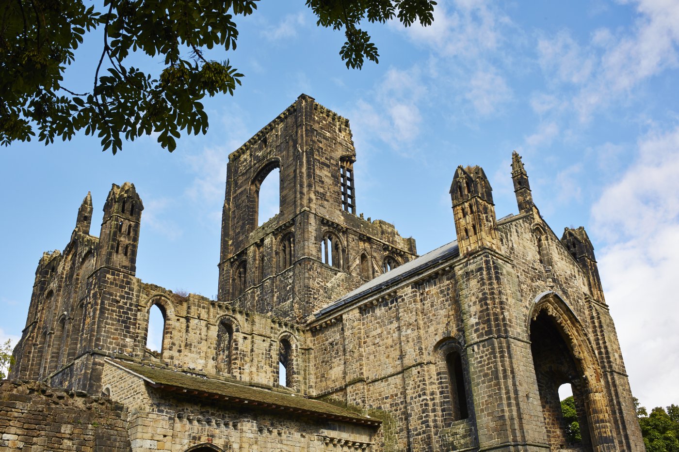 A broad view photo of Kirkstall Abbey in the daytime