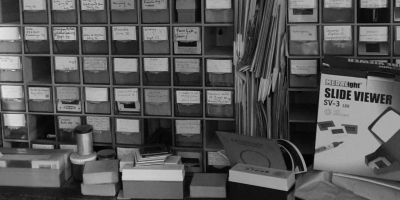 Stack of boxes containing slides in an archive with a slide reader bottom right