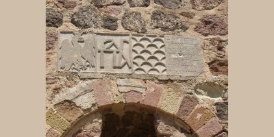 Stone carving above an archway showing heraldic symbols