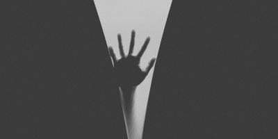 A hand in silhouette, reaching up into the void