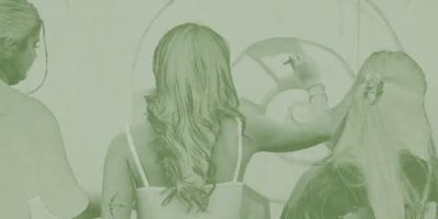 Film still showing three people and an artwork