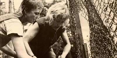 Two Greenham Common women cutting the wire of a fence. Image from the Feminist Archive North