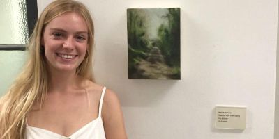 Hannah buchanan with her oil painting on canvas Dappled light interrupting my journey, at the Cut the Mustard BA Fine Art Degree Show 2019