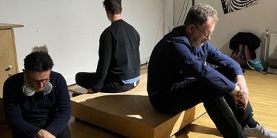 Three men sat down in a studio