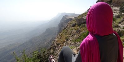 Prof Janet Watson in pink headscarf on a mountain in the middle east