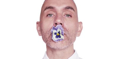 Artist Paul Harfleet with a pansy in his mouth