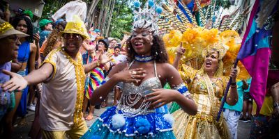 Dancers in bright and elaborate costumes celebrate in a lively carnival.