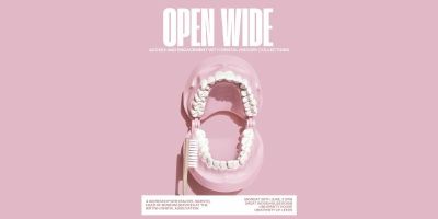 A model of a set of teeth with a toothbrush against a pink background