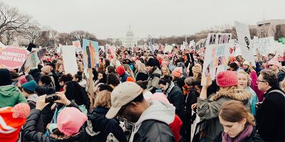 A photo of a crowd holding placards about feminism and Donald Trump at a protest in Washington DC.