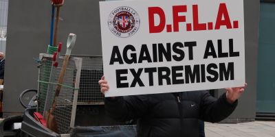 Person holds placard to protest against all extremism