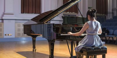 Postgraduate research student playing at grand piano.