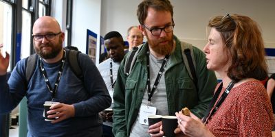 Three people discuss their work during a coffee break at the conference
