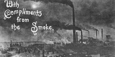 Old black and white postcard of Widnes in the early 1900s, showing chimneys and dark smoke, with the words 'With Compliments from the Smoke'.