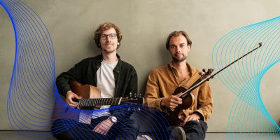 two men sat with string instruments