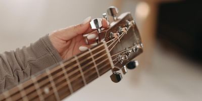 Person tuning an acoustic guitar