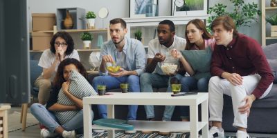 A group of people watch a TV together