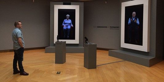 A man looks at two paintings