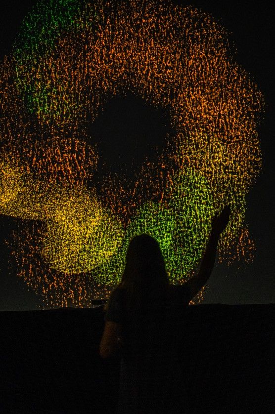 A person stands in silhouette against the Loops for Stagnation installation