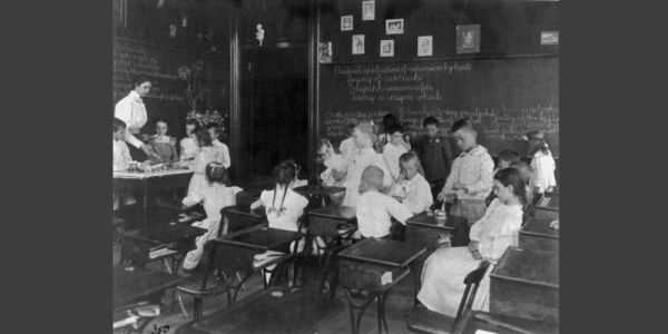 A black and white photograph from the early twentieth century showing schoolgirls doing science experiments