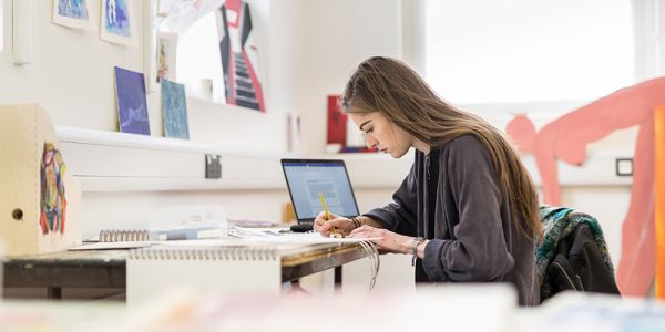 Student at laptop in a studio